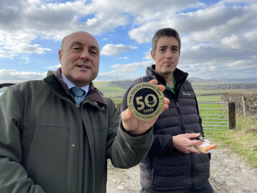 Andrew with Andy Gattiker showing South Downs Way 50th anniversary waymarker